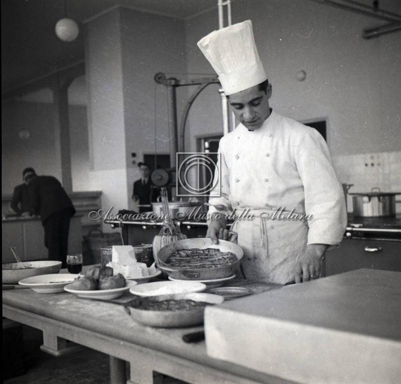 Cuoco al lavoro nelle cucine della mensa