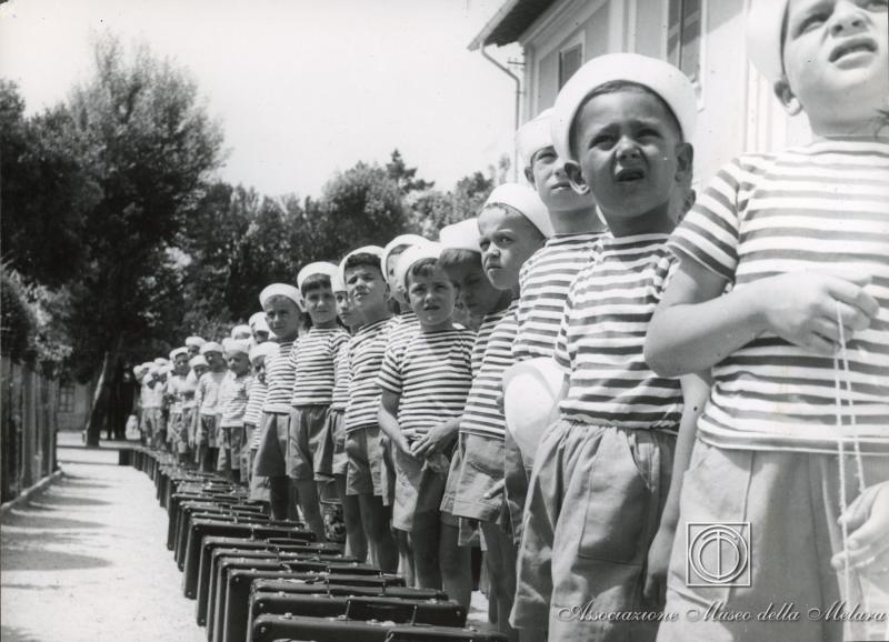 Bambini in fila con le loro valigie