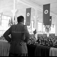 Gerarca di spalle mentre tiene il discorso al comizio fascista